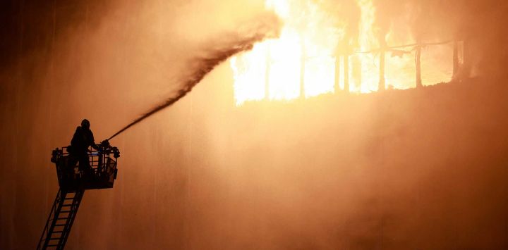 Un bombero utiliza una manguera de agua mientras trabaja para extinguir un incendio que envolvió varios pisos del rascacielos Vjesnik en Zagreb. Foto por AFP