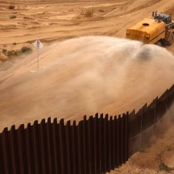 Vehículo de construcción rociando agua a lo largo del muro fronterizo secundario construido entre Santa Teresa, Nuevo México, Estados Unidos y Ciudad Juárez. Foto de HERIKA MARTINEZ / AFP | Foto:AFP