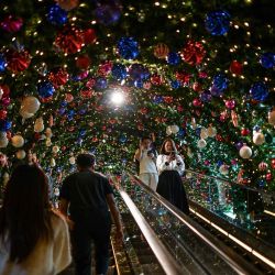 Personas suben por una escalera mecánica junto a decoraciones navideñas en un centro comercial en Bangkok. Foto de Amaury PAUL / AFP | Foto:AFP