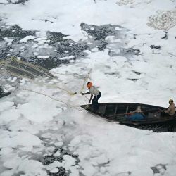Un pescador lanza su red en las aguas del río Yamuna, cargadas de espuma contaminada, en una mañana con smog en Nueva Delhi. Foto de Arun SANKAR / AFP | Foto:AFP