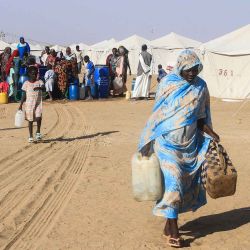 Una mujer sudanesa que huyó de El-Fasher en Darfur lleva bidones de agua en el campamento Al-Afad para personas desplazadas en la ciudad de Al-Dabba, en el norte de Sudán. Foto de Ebrahim Hamid / AFP | Foto:AFP