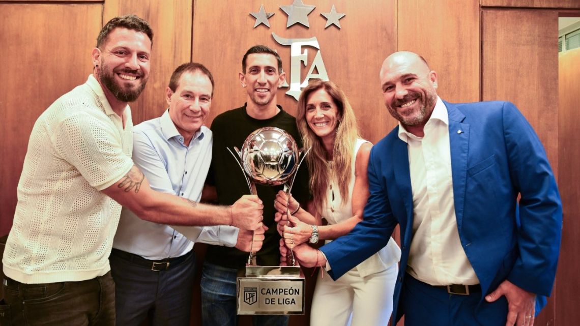 This handout picture released by Liga Profesional de Fútbol press office shows (from left to right) goalkeeper Jorge Broun, Rosario Central Coach Ariel Holan, forward Angel Di Maria, Rosario Central Vice President Carolina Cristinziano and Rosario Central President Gonzalo Belloso with the trophy awarded to the team that accumulated the most points in the General Table of the tournament, in Buenos Aires on November 20, 2025. 