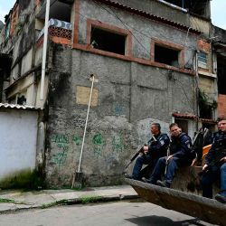 Policías militares son transportados en una retroexcavadora durante una operación para desmantelar barricadas instaladas por criminales en la favela Cidade de Deus en Río de Janeiro, Brasil. Foto de Pablo PORCIUNCULA / AFP | Foto:AFP