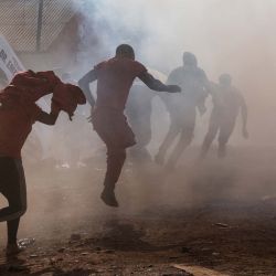 Los seguidores del candidato presidencial de la Plataforma de Unidad Nacional (NPU) y líder de la oposición, Robert Kyagulanyi, también conocido como Bobi Wine, corren para resguardarse del gas lacrimógeno disparado por la policía ugandesa. Foto de Badru Katumba / AFP | Foto:AFP