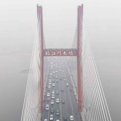 Autos cruzan un puente entre la niebla en la ciudad de Jilin, en la provincia de Jilin, noreste de China. Foto de AFP | Foto:AFP
