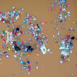 Personas rodeadas de productos flotantes de un supermercado mientras atraviesan aguas de inundación en Hat Yai, en la provincia de Songkhla, al sur de Tailandia. Foto de Arnun Chonmahatrakool / AFP | Foto:AFP