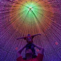 Un hombre y un niño posan para una foto con luces navideñas en Medellín, Colombia. Foto de JAIME SALDARRIAGA / AFP | Foto:AFP