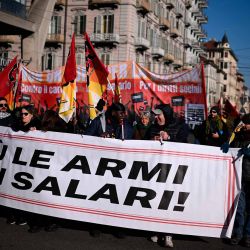 La gente marcha detrás de una pancarta que dice "bajen las armas sobre los salarios" organizada por la Unione Sindacale di Base (USB Unión) en Turín, noroeste de Italia. Foto de MARCO BERTORELLO / AFP | Foto:AFP