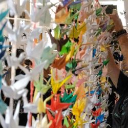 Una mujer cuelga grullas de papel durante una vigilia celebrada frente a los bloques de apartamentos Wang Fuk Court en el distrito de Tai Po de Hong Kong. Foto de Tommy WANG / AFP | Foto:AFP