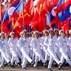 Miembros del servicio laosiano llevan banderas mientras marchan durante el desfile militar del Día Nacional de Laos en la Explanada de That Luang. Foto de AFP | Foto:AFP