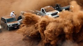 La gente se reúne mientras artistas ambulantes actúan en el desierto de Umm Al Quwain en los Emiratos Árabes Unidos. Foto de FADEL SENNA / AFP