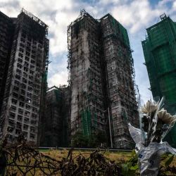 Se ven flores frente a los bloques de apartamentos Wang Fuk Court tras el mortal incendio del 26 de noviembre en el distrito Tai Po de Hong Kong. Foto de Philip FONG / AFP | Foto:AFP