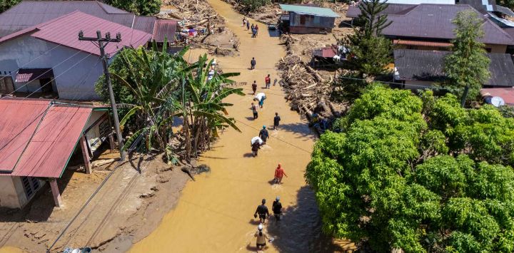 Vista aérea de habitantes del pueblo atravesando el flujo de lodo para encontrar un refugio tras las inundaciones repentinas en la aldea Tukka, Tapanuli Central, provincia de Sumatra del Norte. Foto de YT Hariono / AFP