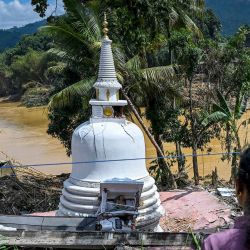 Una mujer observa una estupa que se encuentra en mal estado tras los deslizamientos de tierra ocurridos después del ciclón Ditwah en la ciudad de Gampol. Foto de Ishara S. KODIKARA / AFP | Foto:AFP