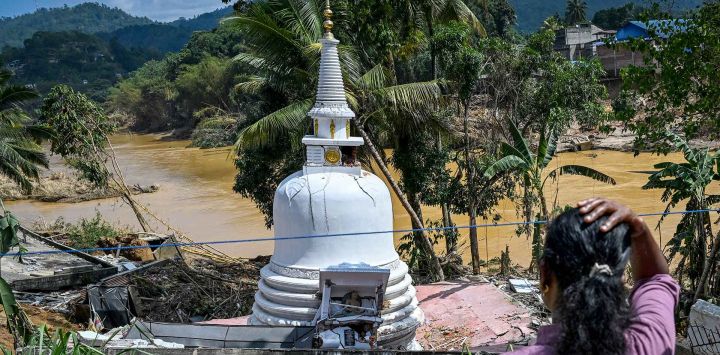 Una mujer observa una estupa que se encuentra en mal estado tras los deslizamientos de tierra ocurridos después del ciclón Ditwah en la ciudad de Gampol. Foto de Ishara S. KODIKARA / AFP