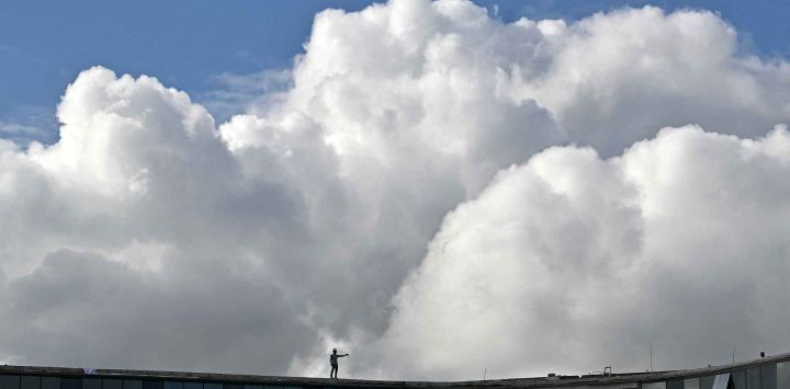 Un obrero se encuentra en lo alto de un edificio en construcción en un día despejado en Bengaluru. Foto de Idrees MOHAMMED / AFP
