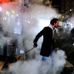 Un hombre cruza una calle mientras pasea a su perro por la noche en el barrio de Manhattan de la ciudad de Nueva York. Foto de CHARLY TRIBALLEAU / AFP | Foto:AFP