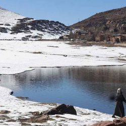 Una mujer camina por la orilla de un lago después de la primera nevada en la estación de esquí Oukaimeden en la región de Al Haouz. Foto de Abdel Majid BZIOUAT / AFP | Foto:AFP