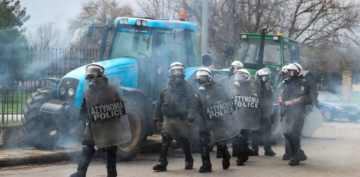Los agentes de la policía antidisturbios utilizan gases lacrimógenos para dispersar a los agricultores que bloquean la carretera que conduce al aeropuerto. Grecia. Foto de AFP