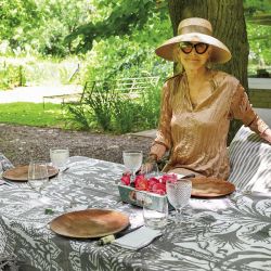 Bajo la sombra frondosa de los tilos, la mesa puesta aguarda el momento del asado. 