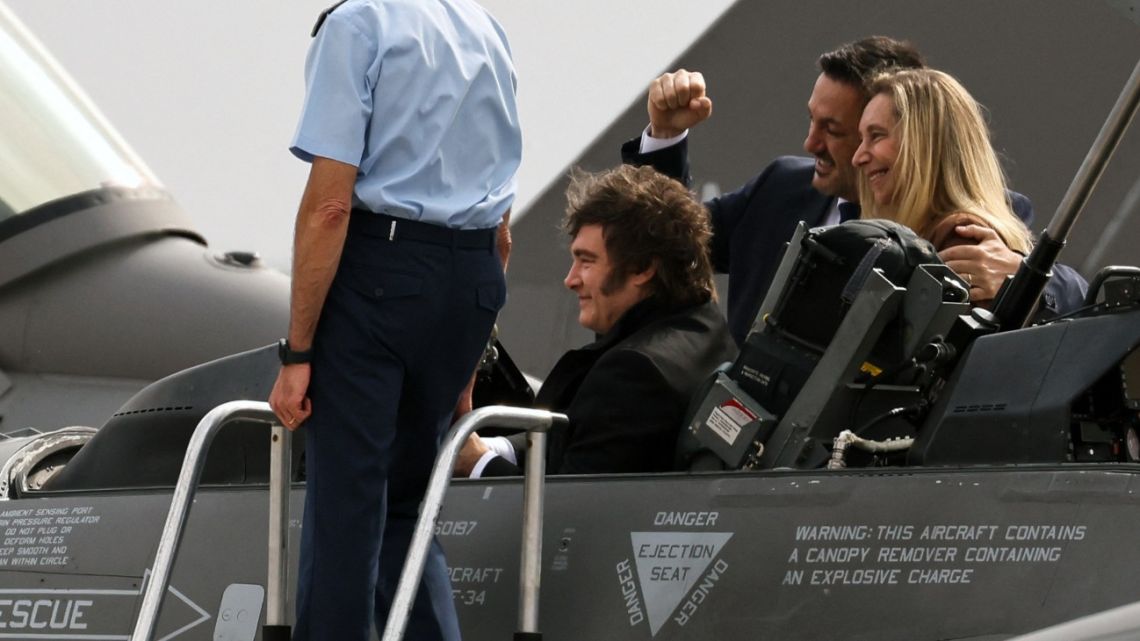 Argentina's President Javier Milei sits on one of the six new F-16 Fighting Falcon jets, next to his sister and General Secretary of the Presidency Karina Milei (R), Defense Minister Luis Petri and Argentina's Air Force Chief of the General Staff Gustavo Valverde (L) during an official ceremony at the 'Area de Material Rio IV' in Río Cuarto, Córdoba Province on December 6, 2025. 
