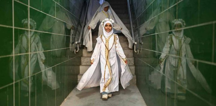 Jóvenes iraquíes que han alcanzado la edad para usar un hiyab, se visten con el velo que usan muchas mujeres musulmanas por primera vez durante una ceremonia organizada en el Estadio Internacional de Basora en la ciudad de Basora, al sur de Irak, 