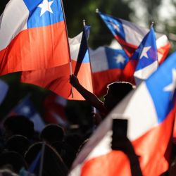 Partidarios del candidato presidencial chileno José Antonio Kast, del Partido Republicano, ondean banderas nacionales tras los primeros resultados de la segunda vuelta de las elecciones presidenciales en Santiago. | Foto:Javier Torres / AFP
