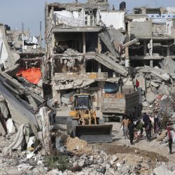 Un trabajador palestino, involucrado en un proyecto de gestión de escombros implementado y supervisado por el PNUD para la Franja de Gaza, maniobra una excavadora para retirar hormigón, metal y escombros de edificios y casas destruidos al sur de la Franja de Gaza, tras una tregua negociada por Estados Unidos que puso fin a la guerra de dos años. | Foto:Bashar Taleb / AFP