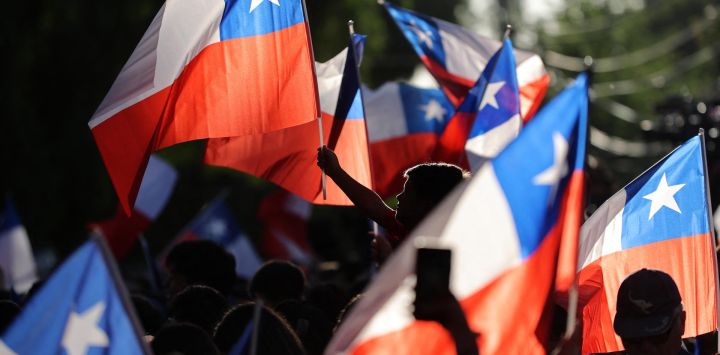 Partidarios del candidato presidencial chileno José Antonio Kast, del Partido Republicano, ondean banderas nacionales tras los primeros resultados de la segunda vuelta de las elecciones presidenciales en Santiago.