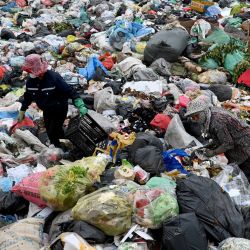 Esta foto muestra a mujeres clasificando residuos plásticos en un vertedero a las afueras de Hanói. Agachada entre montañas de plástico desechado, Lanh desetiqueta botellas de Coca-Cola, Evian y tés vietnamitas para fundirlas en pequeñas bolitas y reutilizarlas. | Foto:NHAC NGUYEN / AFP