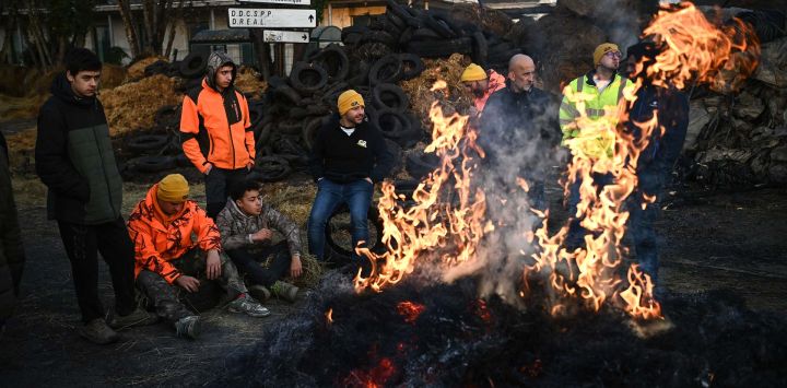 Agricultores del sindicato CR47 (Coordinación Rural 47) protestan junto a una hoguera frente a la Dirección Departamental de Empleo, Trabajo, Solidaridad y Protección de las Poblaciones de Lot-et-Garonne, en Agen, suroeste de Francia.