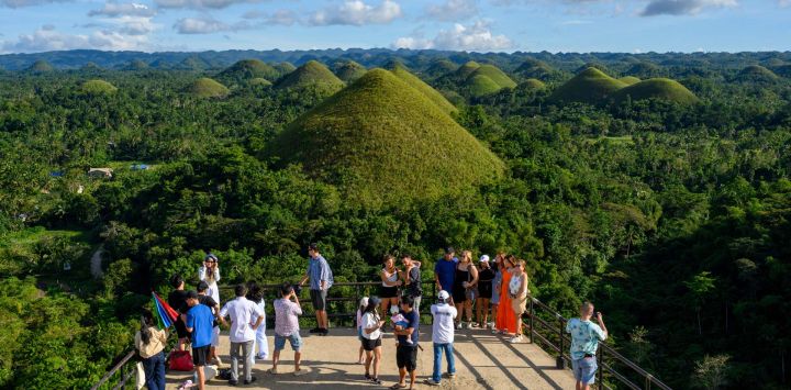 Esta fotografía muestra a turistas contemplando las icónicas Colinas de Chocolate en la isla de Bohol, en la provincia de Visayas Centrales, Filipinas.
