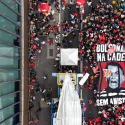 Esta vista aérea muestra a manifestantes portando una enorme pancarta que representa al expresidente Jair Bolsonaro tras las rejas durante una protesta contra el rechazo del Congreso brasileño a un proyecto de ley que modificaría las penas por delitos contra la democracia, reduciendo así la condena de Bolsonaro, y la reciente aprobación de una enmienda constitucional que incorpora la tesis del "Marco Temporal", que ataca los derechos territoriales indígenas, en São Paulo, Brasil. | Foto:Miguel SCHINCARIOL / AFP