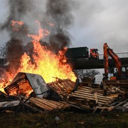 Miembros de la Coordinación Rural, sindicato agrícola francés, se reúnen junto a una hoguera durante un bloqueo agrícola de la autopista A63 en el intercambiador de Cestas, en Gironda, suroeste de Francia. Los agricultores franceses han estado protestando contra el protocolo gubernamental de sacrificio obligatorio de ganado vacuno afectado por la dermatosis nodular contagiosa (Dermatose nodulaire contagieuse), una enfermedad vírica detectada por primera vez en Francia en junio de 2025 que ha provocado el sacrificio de más de 3000 cabezas de ganado en más de 110 brotes en todo el país. | Foto:Christophe Archambault / AFP