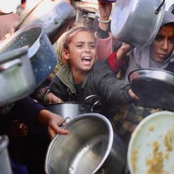 Palestinos desplazados se reúnen para recibir porciones de comida donadas en un comedor social en Khan Yunis, al sur de la Franja de Gaza. El Ministerio de Salud de la Franja de Gaza, gobernada por Hamás, informó que el número total de muertos desde el inicio de la guerra el 7 de octubre de 2023 asciende a 70.668. El alto el fuego promovido por Estados Unidos, vigente desde el 10 de octubre, detuvo la guerra que comenzó tras el mortal ataque de Hamás contra Israel. Sin embargo, sigue siendo frágil, ya que Israel y Hamás se acusan mutuamente casi a diario de incumplimientos. | Foto:Bashar Taleb / AFP