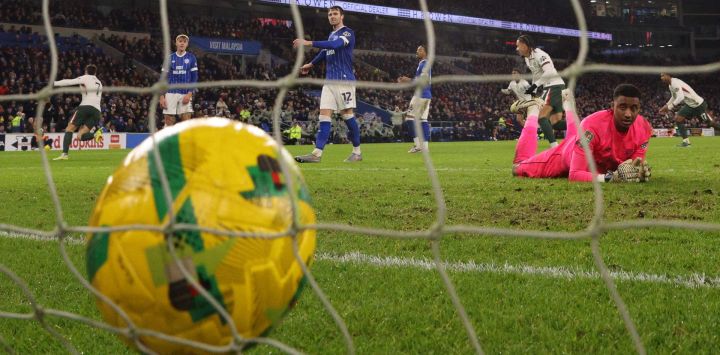 El aruqero inglés del Cardiff City, Nathan Trott, ve un disparo del centrocampista portugués del Chelsea, Pedro Neto (izq.), que marcó el segundo gol del Chelsea durante el partido de cuartos de final de la Copa de la Liga inglesa entre el Cardiff City y el Chelsea en el Cardiff City Stadium, en Cardiff, sur de Gales.