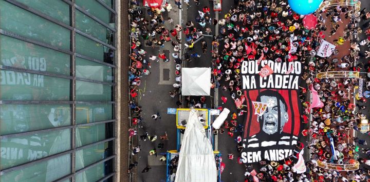 Esta vista aérea muestra a manifestantes portando una enorme pancarta que representa al expresidente Jair Bolsonaro tras las rejas durante una protesta contra el rechazo del Congreso brasileño a un proyecto de ley que modificaría las penas por delitos contra la democracia, reduciendo así la condena de Bolsonaro, y la reciente aprobación de una enmienda constitucional que incorpora la tesis del "Marco Temporal", que ataca los derechos territoriales indígenas, en São Paulo, Brasil.