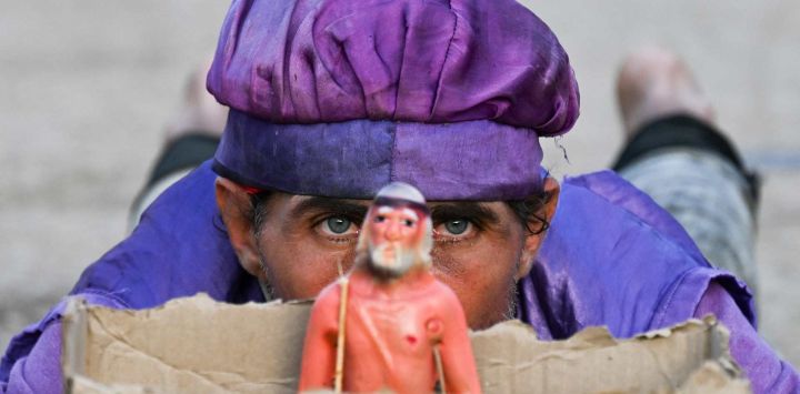 Un hombre observa desde detrás de una imagen de San Lázaro durante la peregrinación al Santuario de San Lázaro en El Rincón, cerca de La Habana, Cuba. Cada año en Cuba, los peregrinos rezan a San Lázaro por los católicos y a Babalú Ayé por las religiones afrocubanas, pidiendo salud, sanación y prosperidad en medio de la grave crisis económica que afecta a la isla.