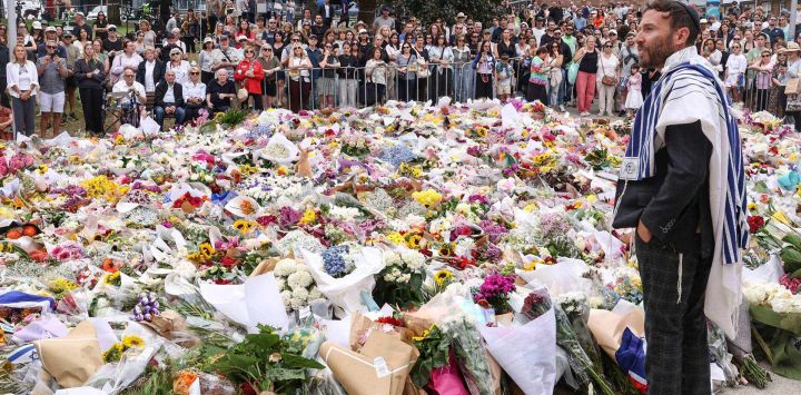 Un rabino habla con los dolientes en un homenaje frente al Bondi Pavilion en Sídney, en honor a las víctimas del tiroteo de Bondi Beach. Los líderes australianos acordaron endurecer las leyes de armas después de que los atacantes mataran a 15 personas en un festival judío en Bondi Beach, el peor tiroteo masivo en décadas, denunciado como "terrorismo" antisemita por las autoridades.