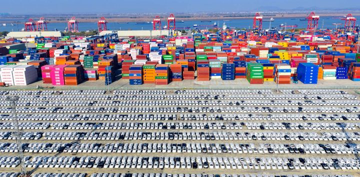 Vista aérea tomada con un dron de vehículos fabricados en China esperando a ser exportados en un muelle de contenedores del puerto de Nanjing, en la provincia de Jiangsu, en el este de China.