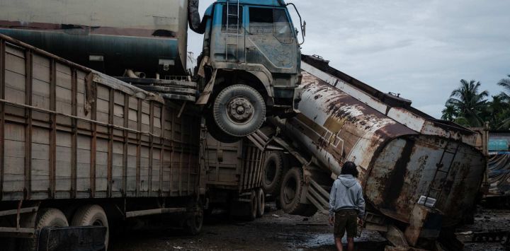 Camiones cisterna de aceite de palma se encuentran dañados tras una inundación repentina en un taller de reparación de vehículos en Aceh Tamiang, en el norte de Sumatra.