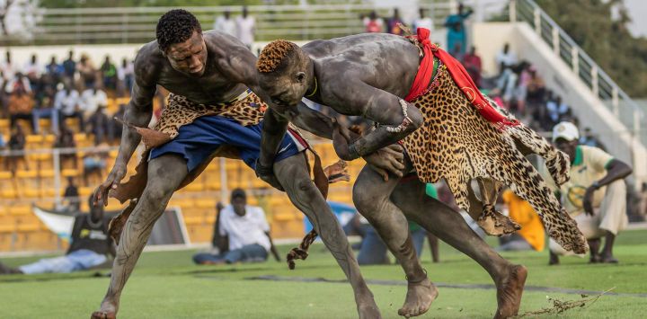 Los luchadores forcejean intentando derribarse durante un combate cultural por la paz en Yuba. La lucha tradicional es un deporte popular en Sudán del Sur, con varios eventos a lo largo del año que destacan los esfuerzos por aliviar tensiones y promover la unidad a través del patrimonio cultural compartido, uniendo a las comunidades en un espíritu de paz y reconciliación.