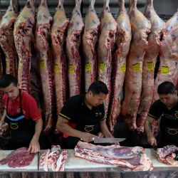 Trabajadores cortan carne en el frigorífico H&H de Buenos Aires. Junto con su vecino Uruguay, Argentina sigue siendo líder mundial en consumo de carne, pero nunca había comido tan poco: la relación histórica, casi identitaria, de los argentinos con la carne está experimentando un cambio lento y profundo, perdiendo protagonismo, con un futuro centrado en la exportación. | Foto:LUIS ROBAYO / AFP