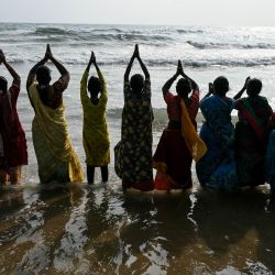 Mujeres se reúnen para orar por las víctimas del tsunami del Océano Índico de 2004 durante una ceremonia en la playa de Pattinapakkam en Chennai, India. | Foto:R. Satish Babu / AFP