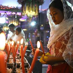 Un devoto cristiano enciende velas y ofrece una oración en la Basílica de Santa María de Bengaluru, India. | Foto:IDREES MOHAMMED / AFP