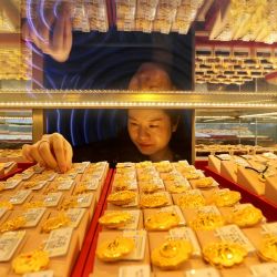 Una vendedora ajusta joyas de oro para la venta en una tienda de Lianyungang, en la provincia oriental china de Jiangsu. | Foto:AFP