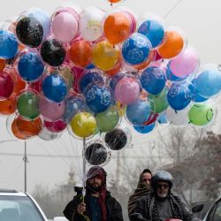 Un vendedor de globos afgano se abre paso entre el tráfico mientras busca clientes en una transitada calle de Kabul. | Foto:WAKIL KOHSAR / AFP