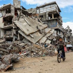 Imagen de un niño palestino desplazado circulando en una bicicleta en el campamento de refugiados de Jabalia, en el norte de la Franja de Gaza. | Foto:Xinhua/Rizek Abdeljawad