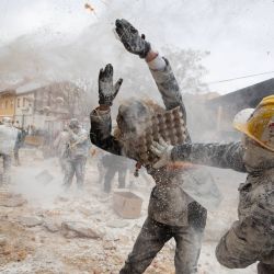 Los participantes, vestidos con uniformes militares simulados, participan en la batalla de harina y huevos "Els Enfarinats" en Ibi, ciudad del sureste de España. | Foto:JAIME REINA / AFP