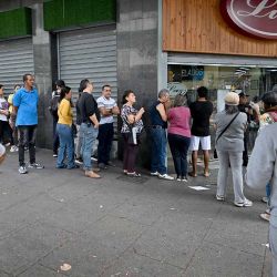  Personas forman fila frente a un supermercado en Caracas el 3 de enero de 2026, después de que las fuerzas estadounidenses capturaran al líder venezolano Nicolás Maduro. El presidente Donald Trump declaró el sábado que las fuerzas estadounidenses capturaron al líder venezolano Nicolás Maduro tras bombardear la capital, Caracas, y otras ciudades, en un dramático giro de los acontecimientos, marcando meses de tensión entre Trump y su archienemigo venezolano. (Foto de Juan Barreto/AFP) | Foto:afp